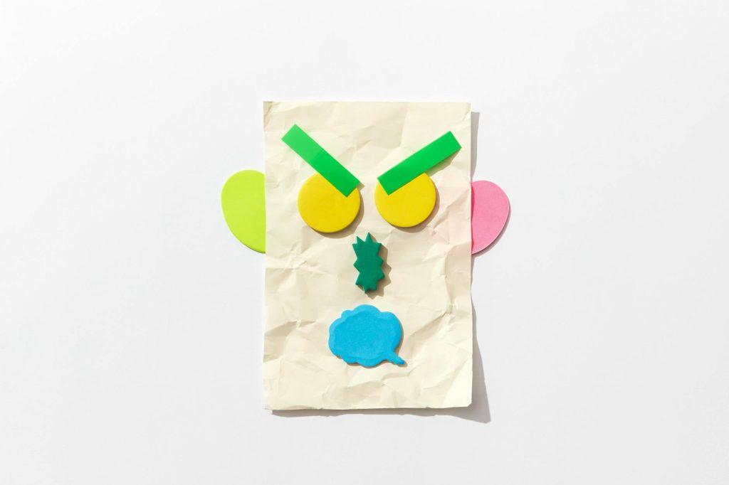 Colorful abstract paper art piece displaying an expressive face on crumpled paper.