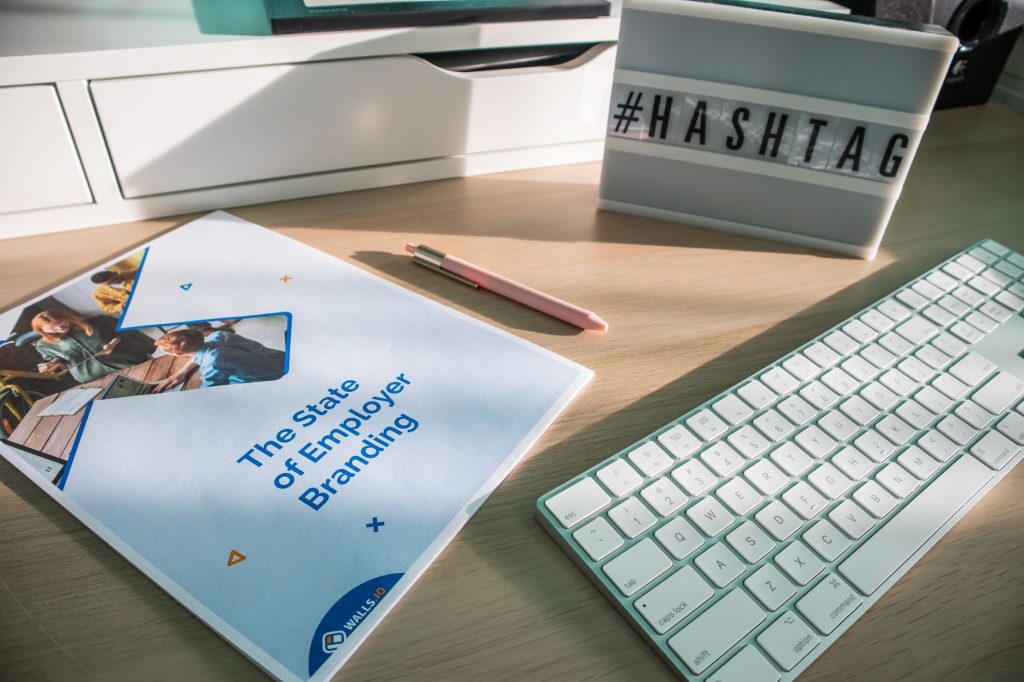 A contemporary workspace with a branding report and hashtag sign highlighting employer branding.